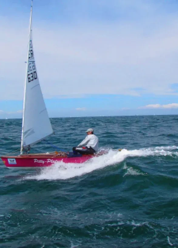 Voilier rouge glissant sur mer agitée, S'installer à l'Île Maurice, Serena Résidences